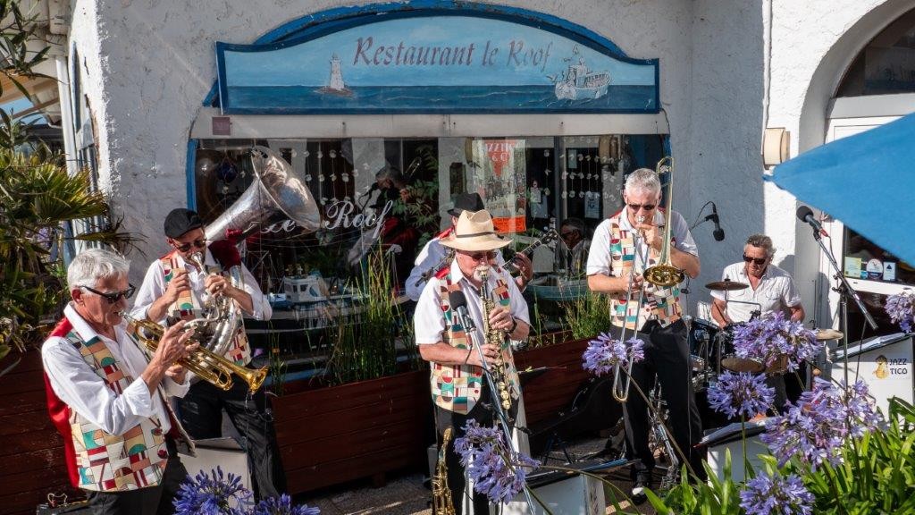Jazz Tico joue en plein air devant le Restaurant le Roof à Trégastel, au soleil, parmi les agapanthes