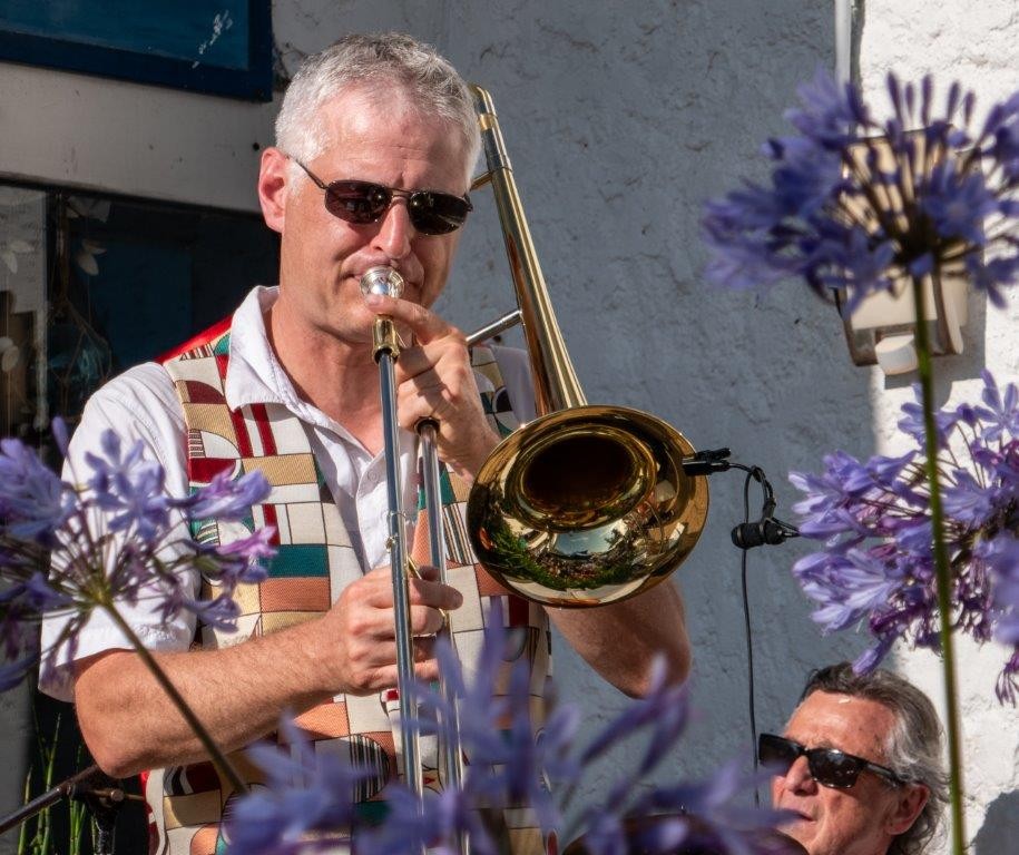 Le tromboniste de Jazz Tico entre les agapanthes, le batteur assis derrière lui